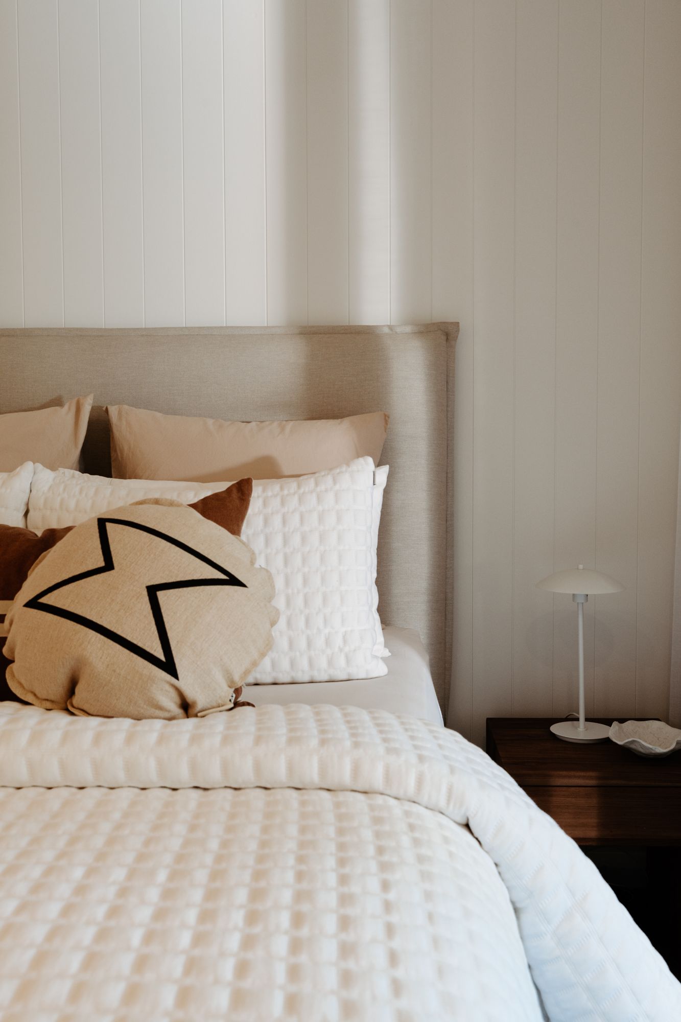 Bedroom with a VJ panelled feature wall and upholstered bedhead