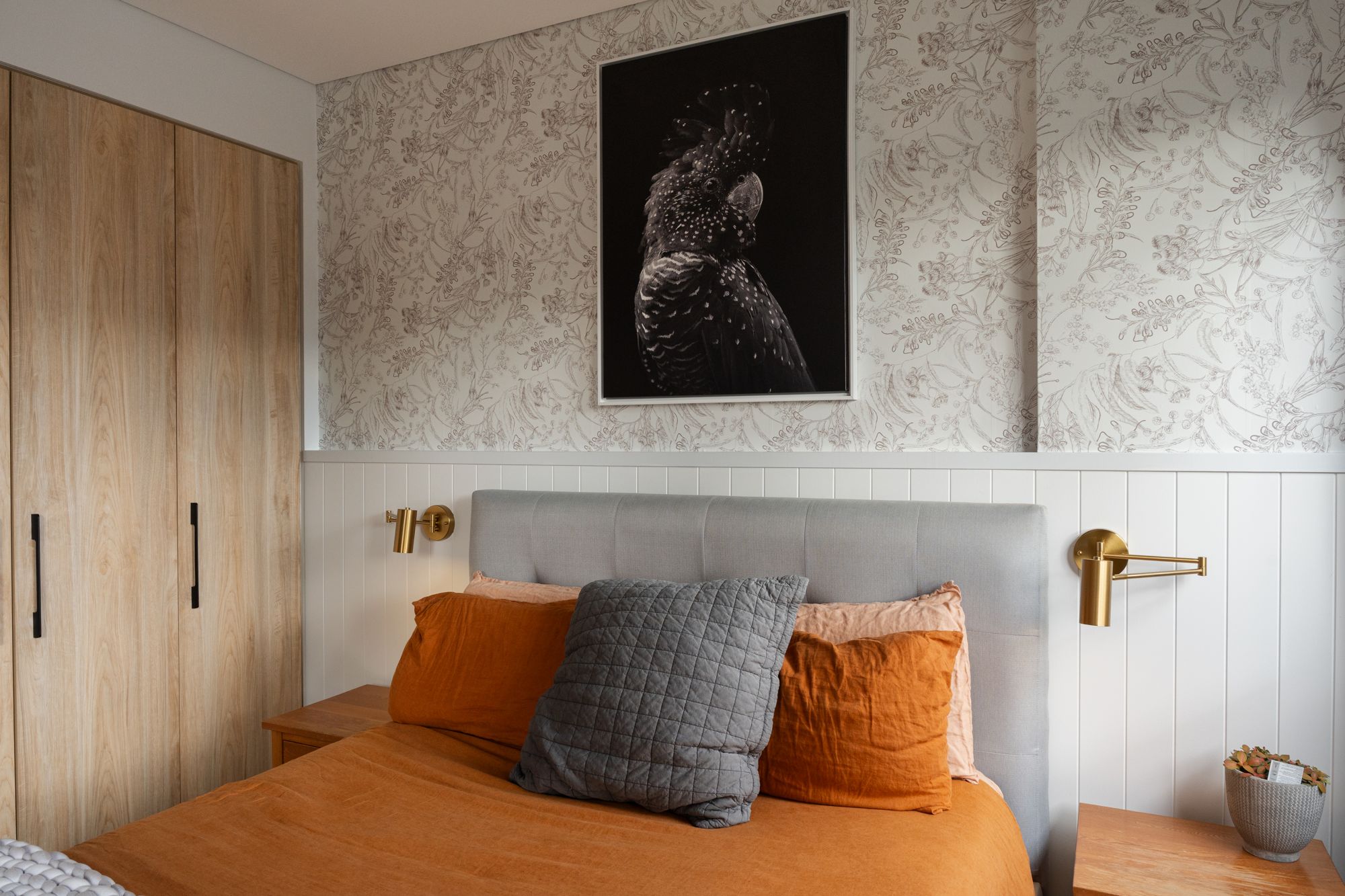 Bedroom with floor-to-ceiling built-in timber wardrobes beside a feature wallpaper wall