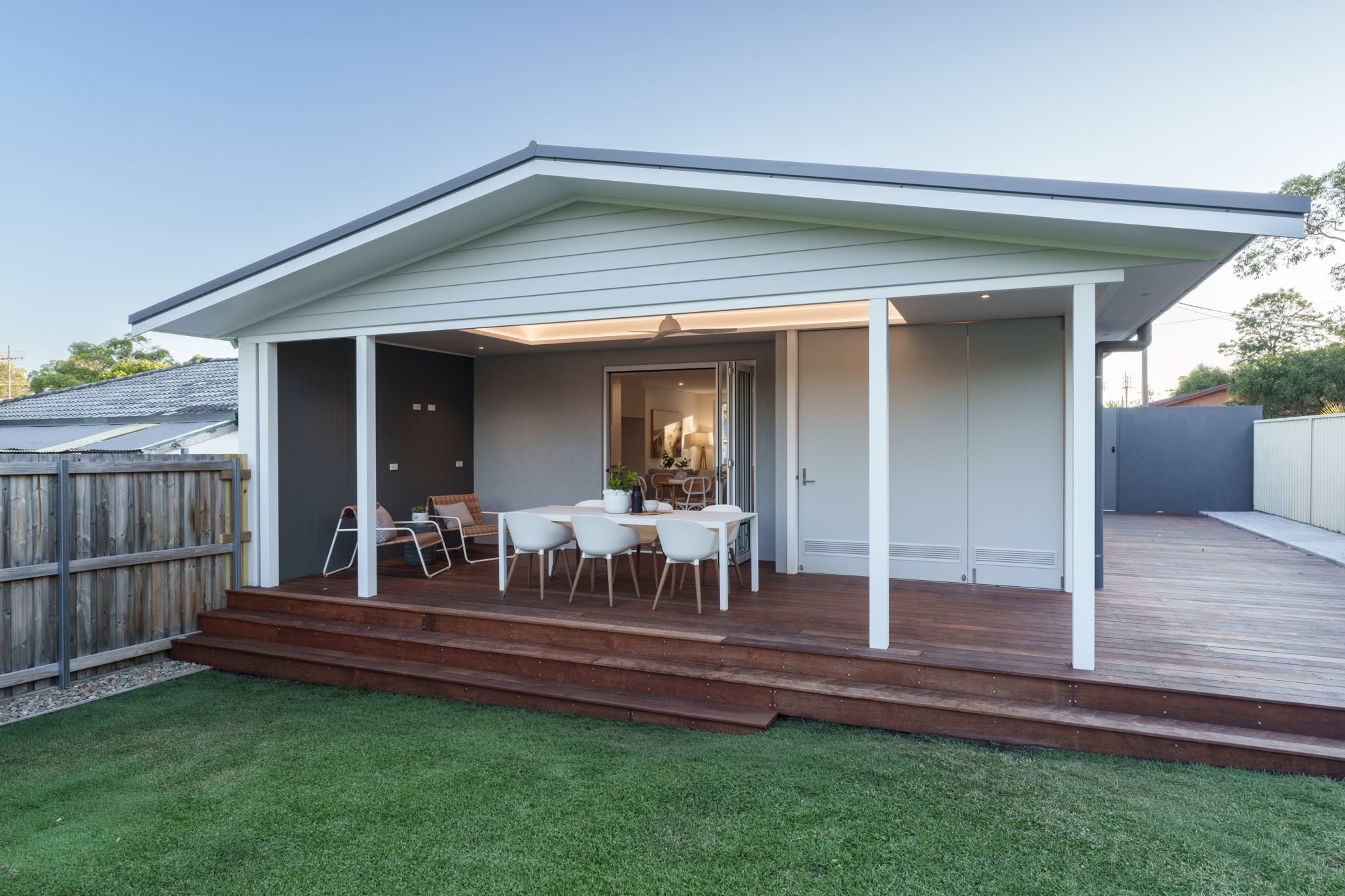 Covered timber rear deck and alfresco dining area with steps down to the lawn