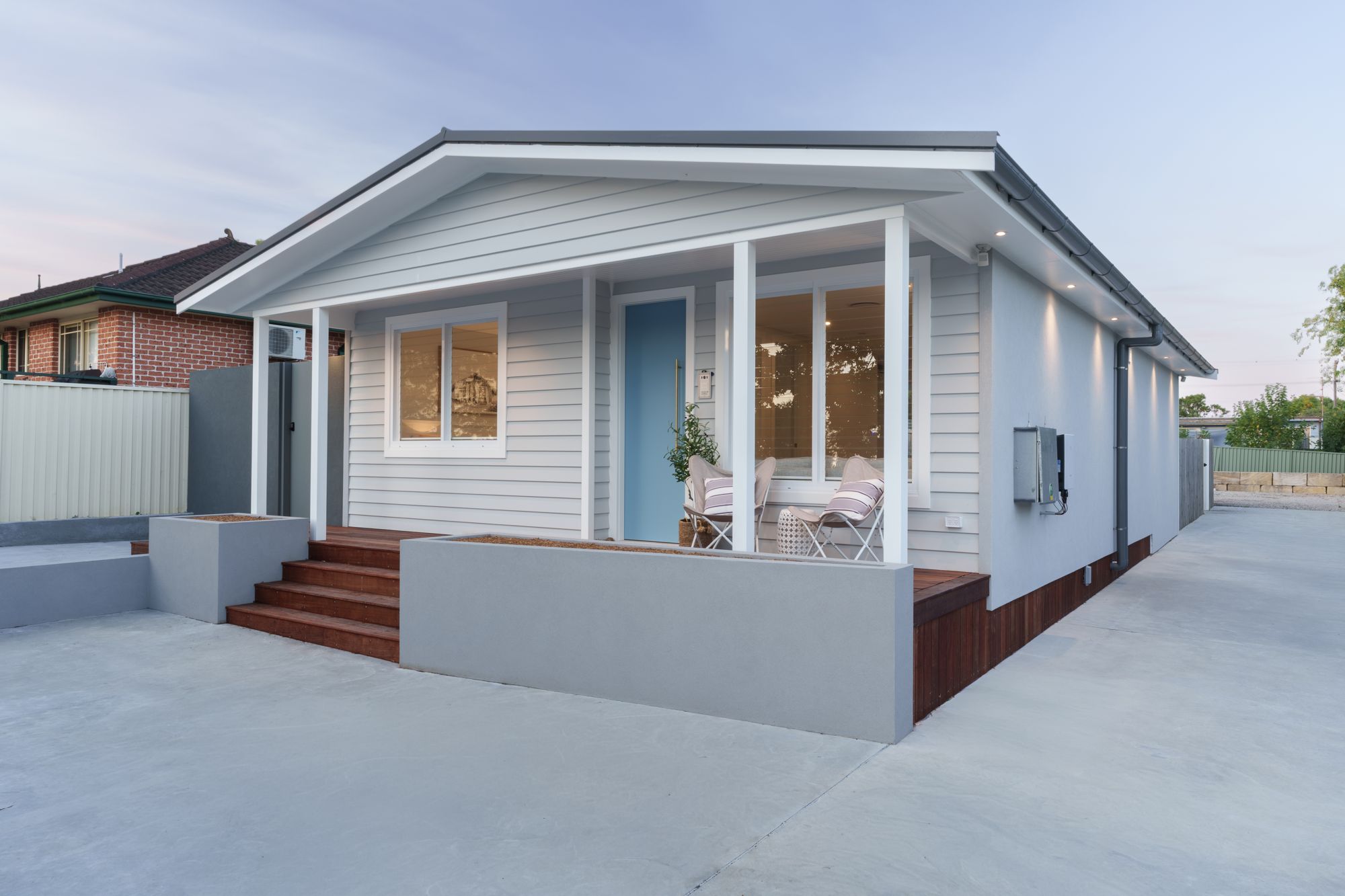 Renovated weatherboard cottage with a white gable front, blue front door and new timber entry deck